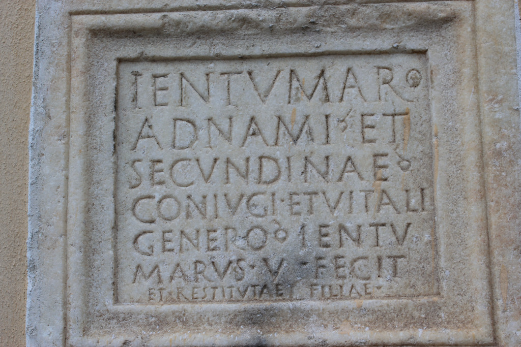 Eingemauerte und umramte Inschrift eingemeiselt in Stein in lateinischer Sprache.